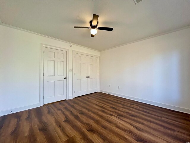 unfurnished bedroom featuring dark hardwood / wood-style floors, ornamental molding, and ceiling fan