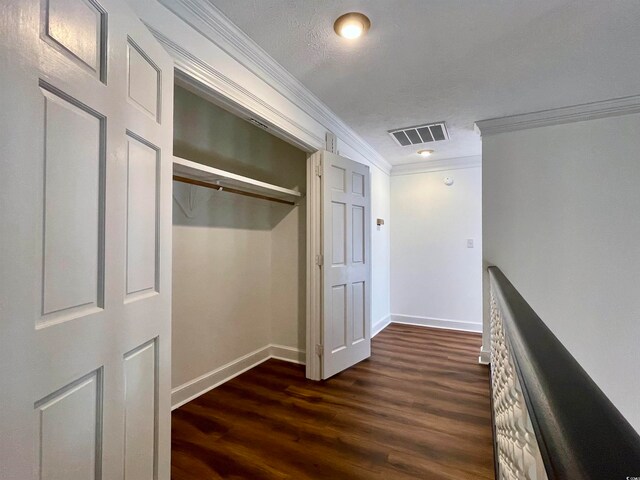 hallway featuring a textured ceiling, dark wood-type flooring, and ornamental molding