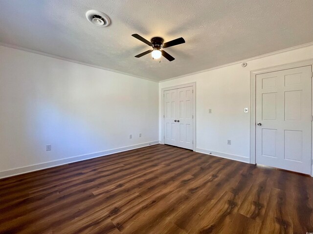 spare room featuring dark hardwood / wood-style flooring, ceiling fan, ornamental molding, and a textured ceiling