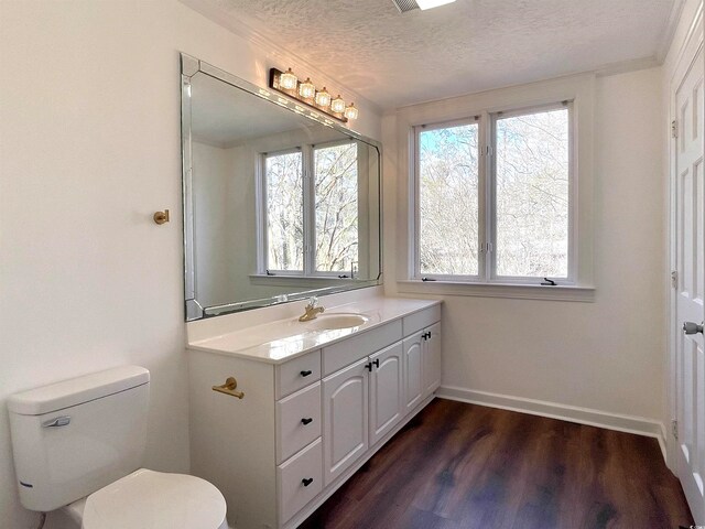 bathroom with hardwood / wood-style flooring, toilet, a textured ceiling, and vanity