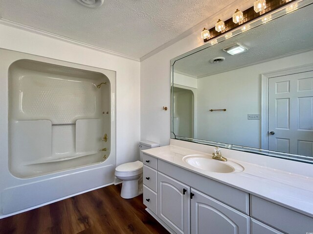 full bathroom featuring toilet, vanity, a textured ceiling, wood-type flooring, and shower / tub combination