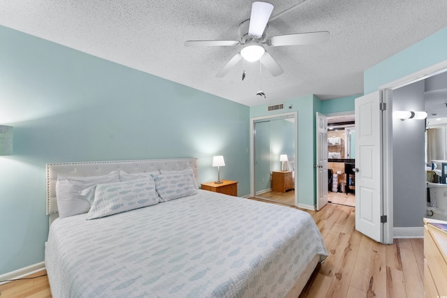 bedroom featuring a textured ceiling, a closet, ceiling fan, and light hardwood / wood-style flooring