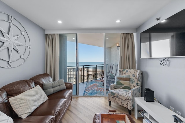 living room with a water view and light hardwood / wood-style floors