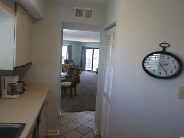 interior space featuring sink, white dishwasher, and light tile floors