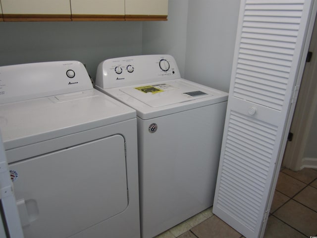 clothes washing area with light tile floors and washing machine and clothes dryer