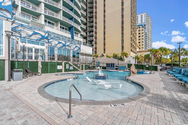 view of swimming pool featuring a patio and central air condition unit