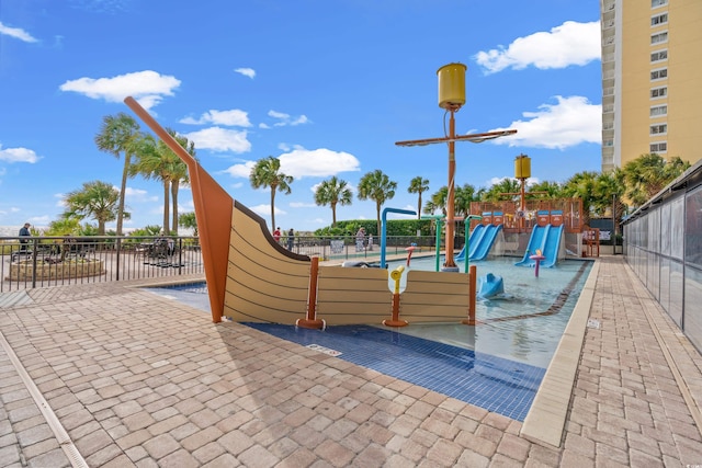 view of playground with a patio and a fenced in pool