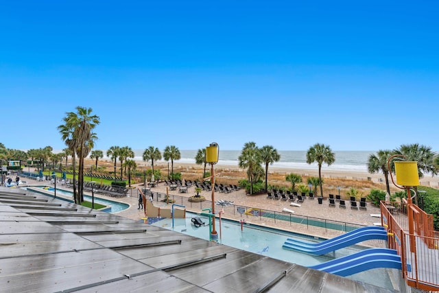 view of pool with a playground and a water view