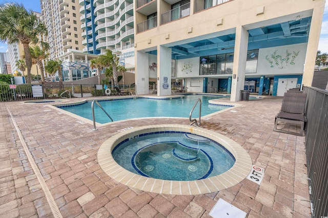 view of pool featuring a hot tub and a patio area