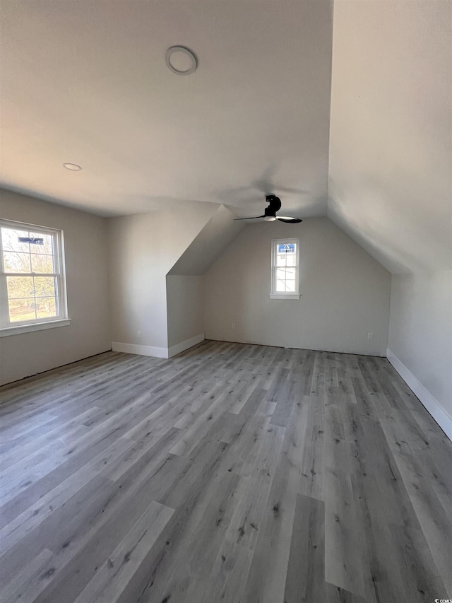 additional living space featuring ceiling fan, baseboards, lofted ceiling, and wood finished floors