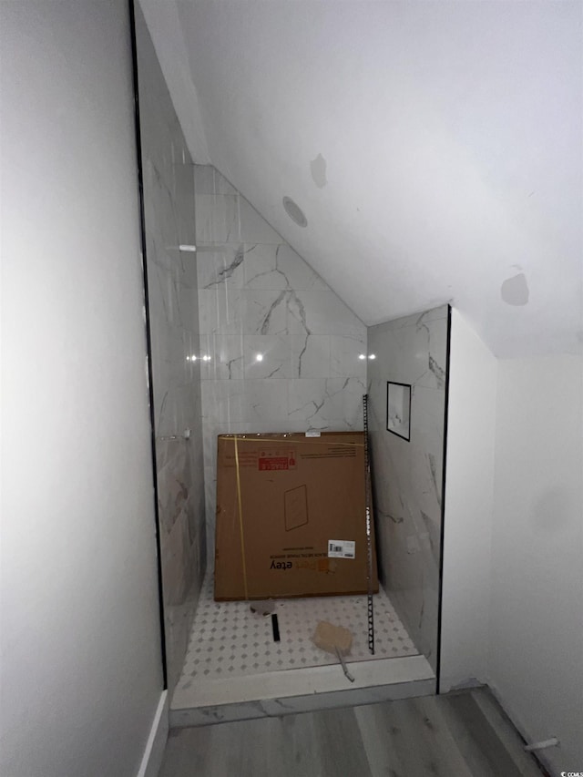 bathroom with lofted ceiling and wood finished floors