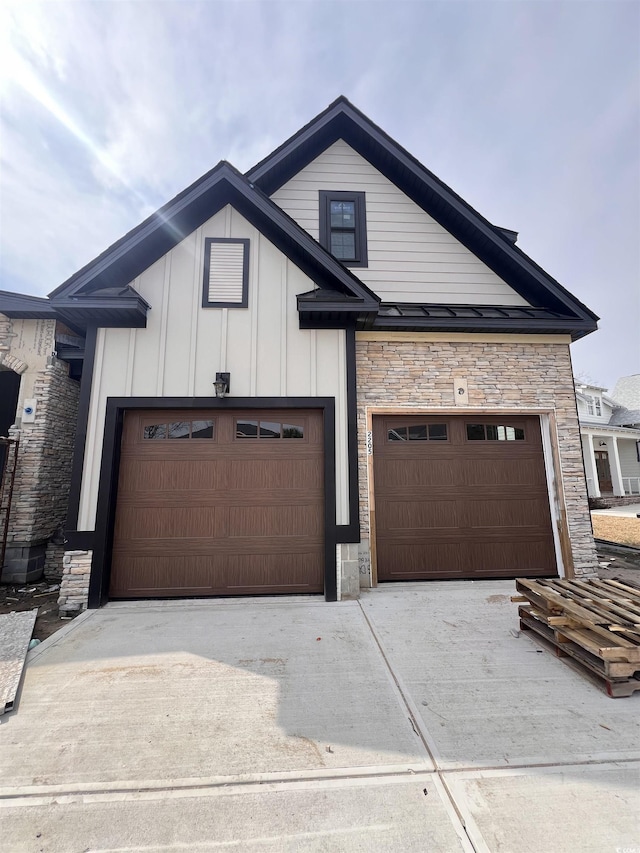 modern farmhouse style home with board and batten siding, concrete driveway, and stone siding