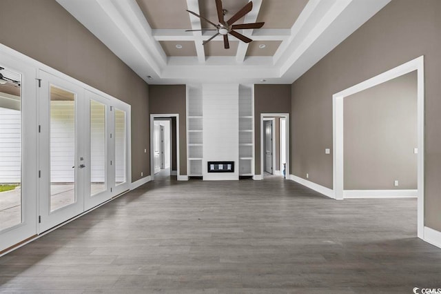 unfurnished living room with french doors, a high ceiling, wood finished floors, coffered ceiling, and a ceiling fan