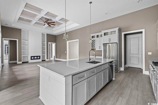 kitchen featuring plenty of natural light, sink, pendant lighting, and light hardwood / wood-style flooring