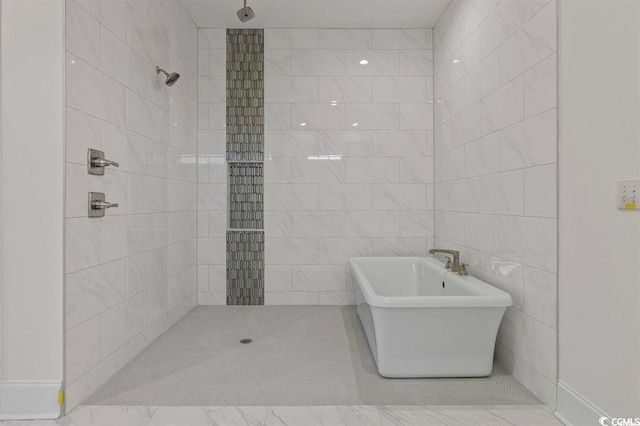 full bathroom featuring tile walls, walk in shower, and a freestanding tub