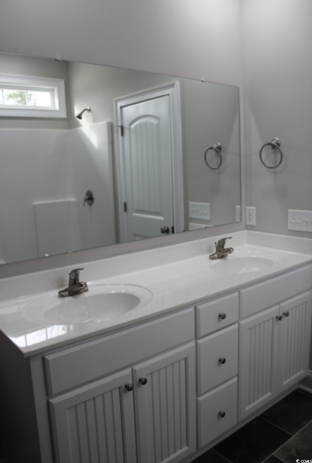 bathroom featuring tile patterned floors, double vanity, and a sink