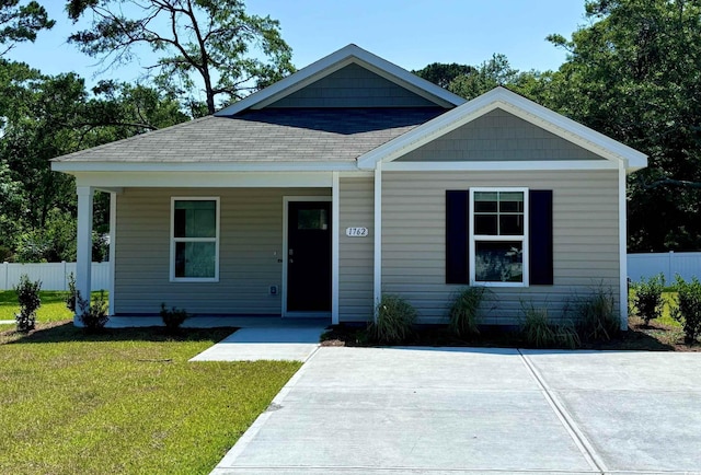 view of front of house featuring covered porch and a front yard