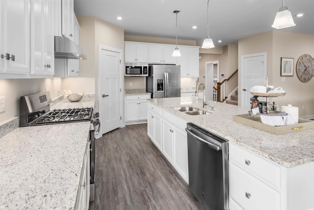 kitchen with appliances with stainless steel finishes, an island with sink, dark wood-type flooring, sink, and white cabinets