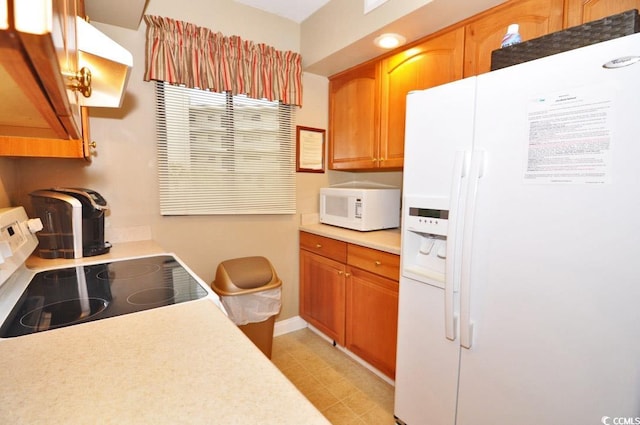 kitchen with white appliances and light tile flooring