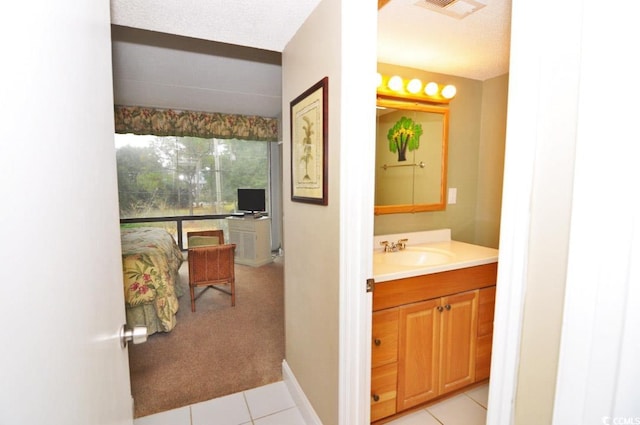 bathroom with a textured ceiling, vanity, and tile flooring