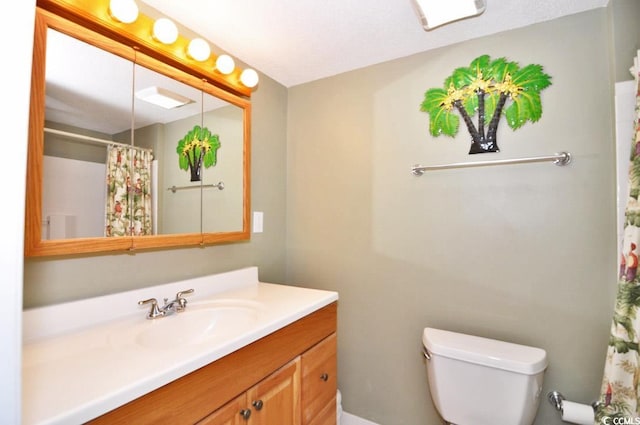 bathroom with vanity with extensive cabinet space, toilet, and a textured ceiling