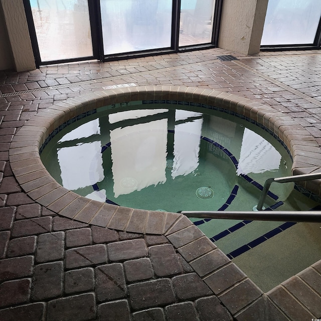 view of swimming pool featuring a hot tub