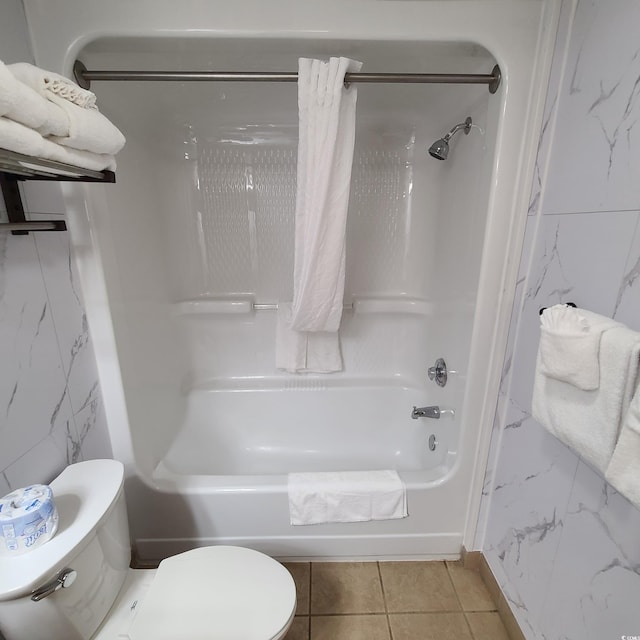 bathroom with toilet, tile floors, tile walls, and tub / shower combination