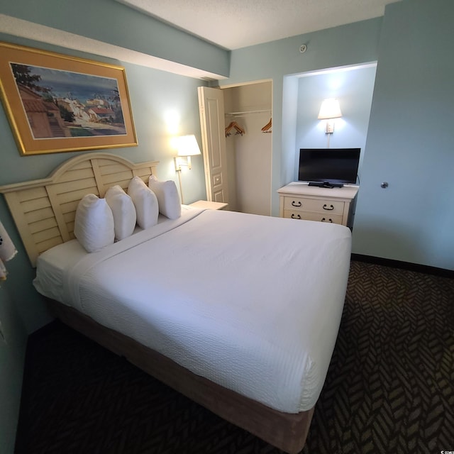 carpeted bedroom with a closet and a textured ceiling