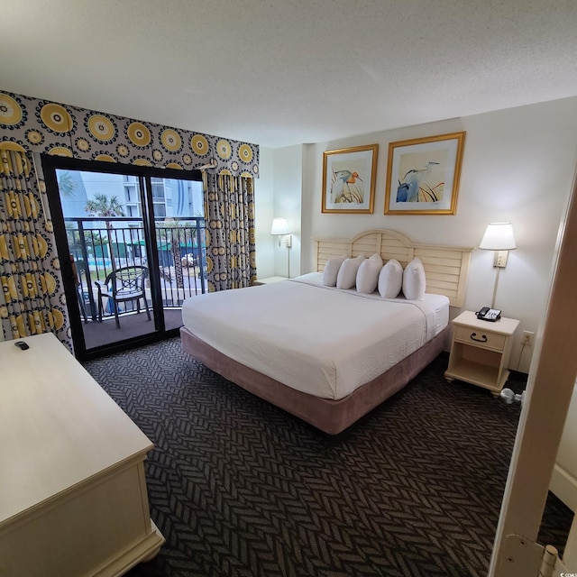 bedroom with access to exterior, dark carpet, and a textured ceiling