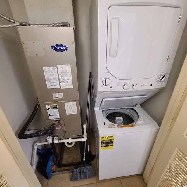 washroom with light tile flooring and stacked washer and clothes dryer