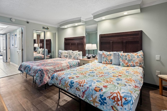 bedroom with ornamental molding, a textured ceiling, hardwood / wood-style floors, and a closet