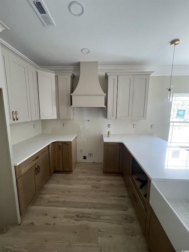 721 10th Ave S, Surfside Beach, SC 29575 - kitchen featuring custom exhaust hood, light wood-style floors, pendant lighting, and ornamental molding
