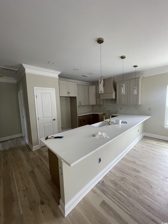 721 10th Ave S, Surfside Beach, SC 29575 - kitchen featuring custom range hood, ornamental molding, light wood finished floors, decorative light fixtures, and a peninsula
