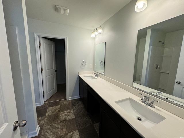 bathroom with double sink vanity, tile flooring, a shower, and toilet