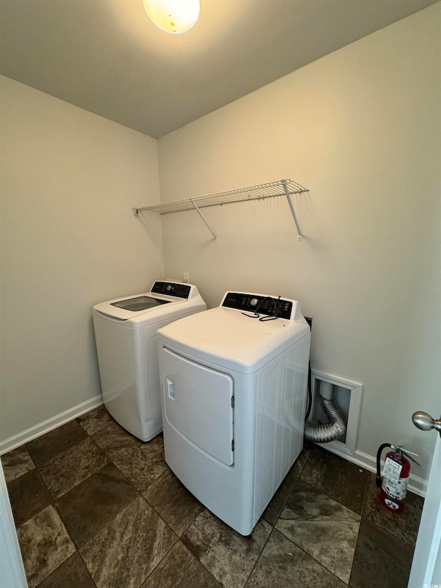 laundry room featuring dark tile flooring and washer and dryer