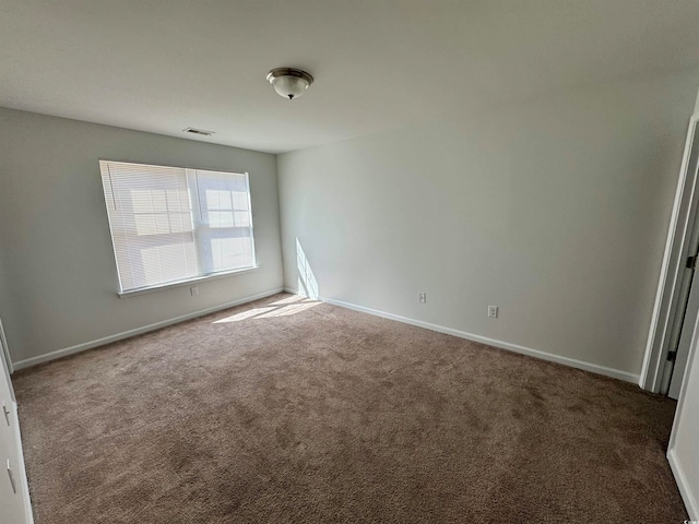 unfurnished room featuring dark colored carpet