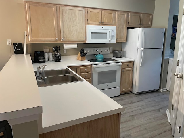 kitchen featuring light brown cabinets, sink, white appliances, and light wood-type flooring