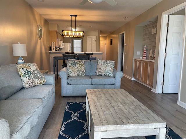 living room with dark hardwood / wood-style floors and ceiling fan with notable chandelier