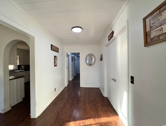 hallway featuring dark hardwood / wood-style flooring and crown molding