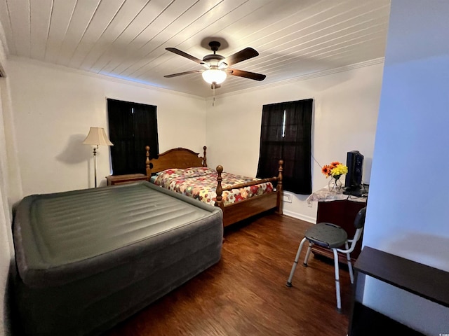 bedroom featuring dark hardwood / wood-style flooring, ceiling fan, and crown molding