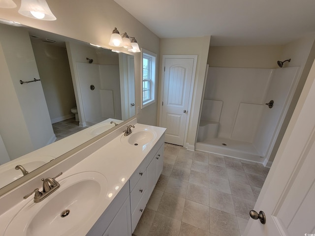 bathroom with toilet, vanity, a shower, and tile patterned floors