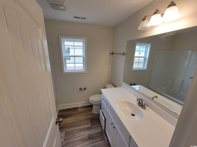 bathroom featuring vanity, toilet, a shower, and hardwood / wood-style floors