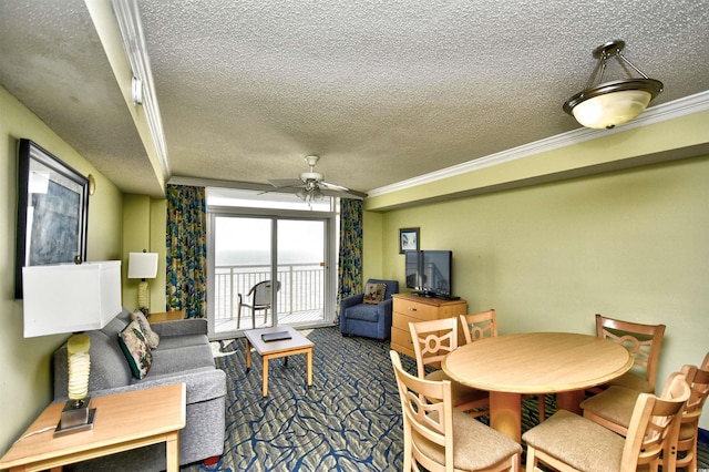 living room featuring ceiling fan, a textured ceiling, ornamental molding, and dark colored carpet