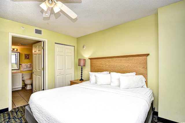 bedroom with tile flooring, a closet, ceiling fan, and a textured ceiling