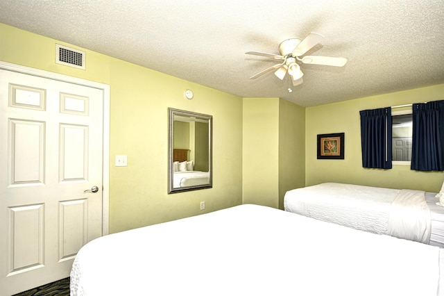 bedroom with ceiling fan and a textured ceiling