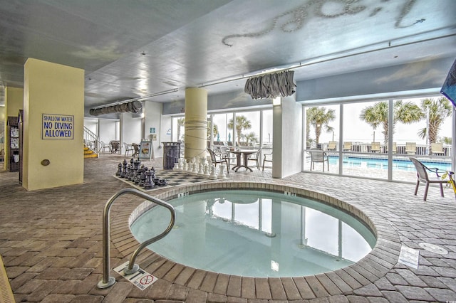 view of swimming pool featuring a hot tub