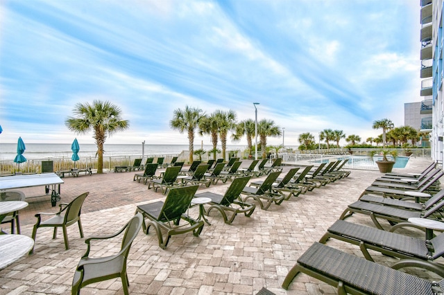 view of patio featuring a water view and a community pool