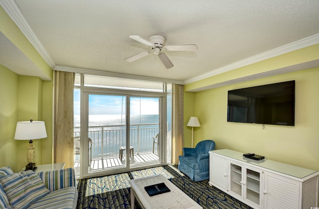 living room featuring a water view, a textured ceiling, ceiling fan, and ornamental molding