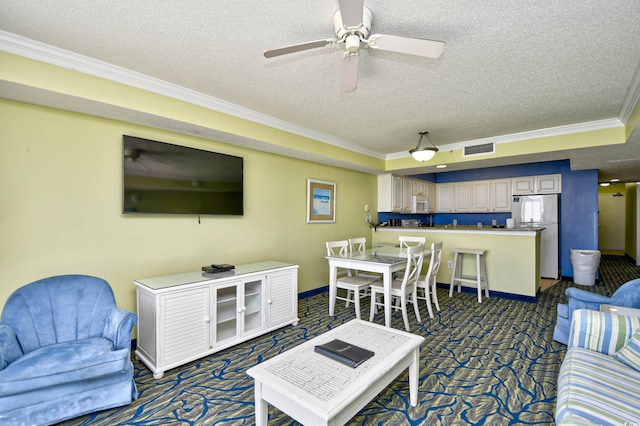 carpeted living room with ceiling fan, a textured ceiling, and ornamental molding