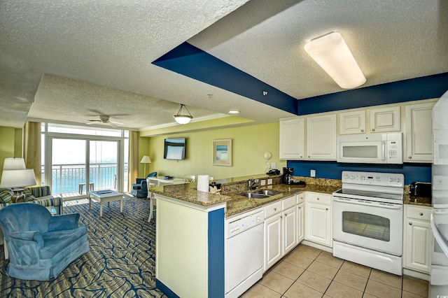 kitchen with kitchen peninsula, white appliances, ceiling fan, and white cabinets